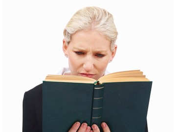 woman reading a book and looking mighty perplexed
